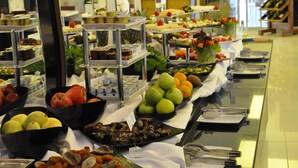 Un bufé con diversos alimentos y utensilios colocados sobre una larga mesa.