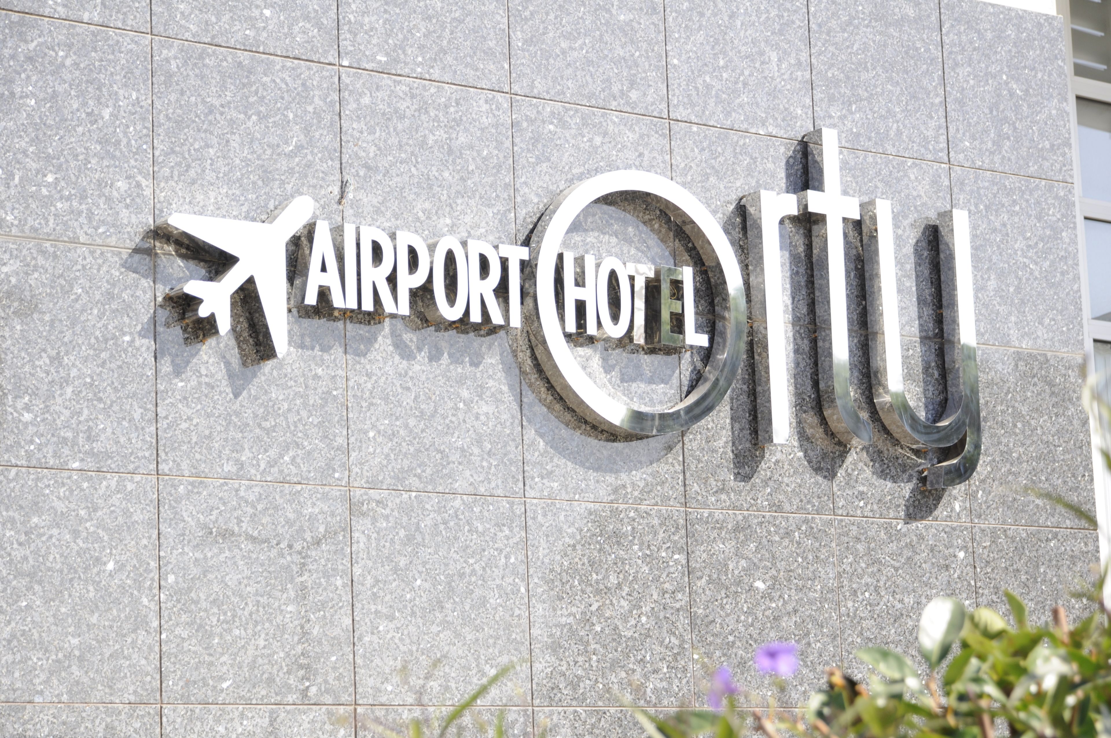 Señal para el Hotel Aeropuerto con un avión estilizado y el nombre del hotel.