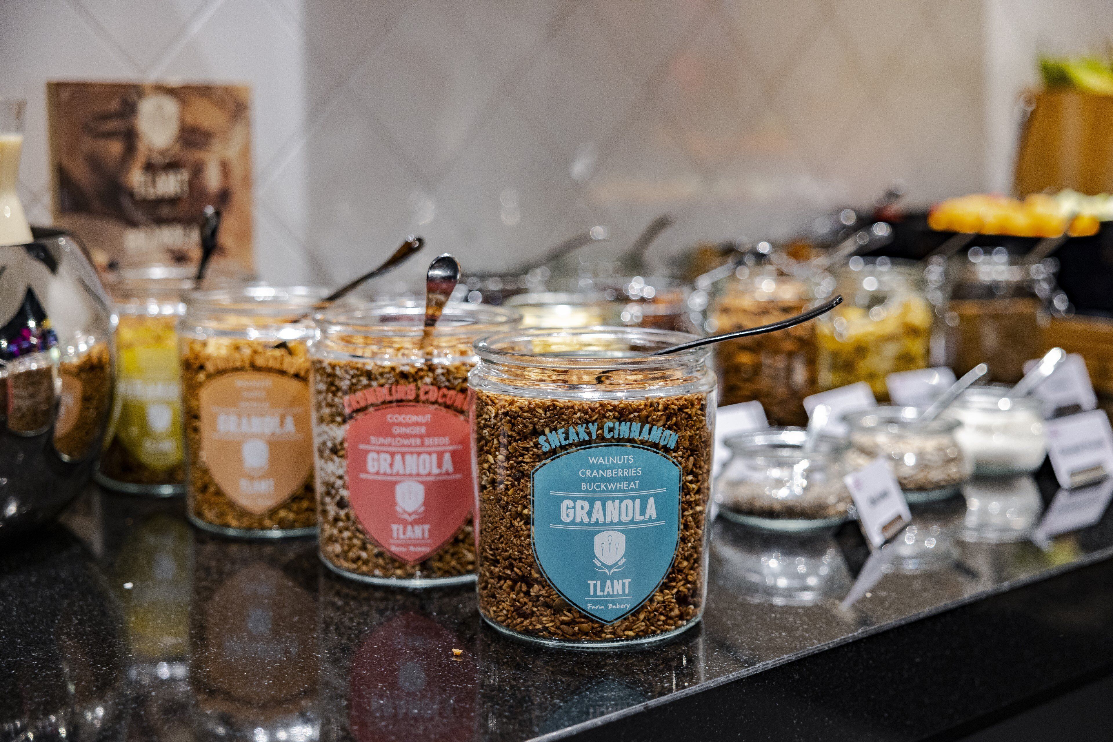 Un bufé con varios recipientes de granola y otros alimentos.