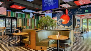 A restaurant interior with a checkered floor, green and red shoji screens, and a large mural of a wave. - Crowne Plaza Amsterdam South by IHG (Amsterdam)