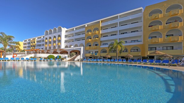 A hotel with a large swimming pool, multiple balconies, and sun loungers. - Paladim & Alagoamar Hotels (Albufeira)