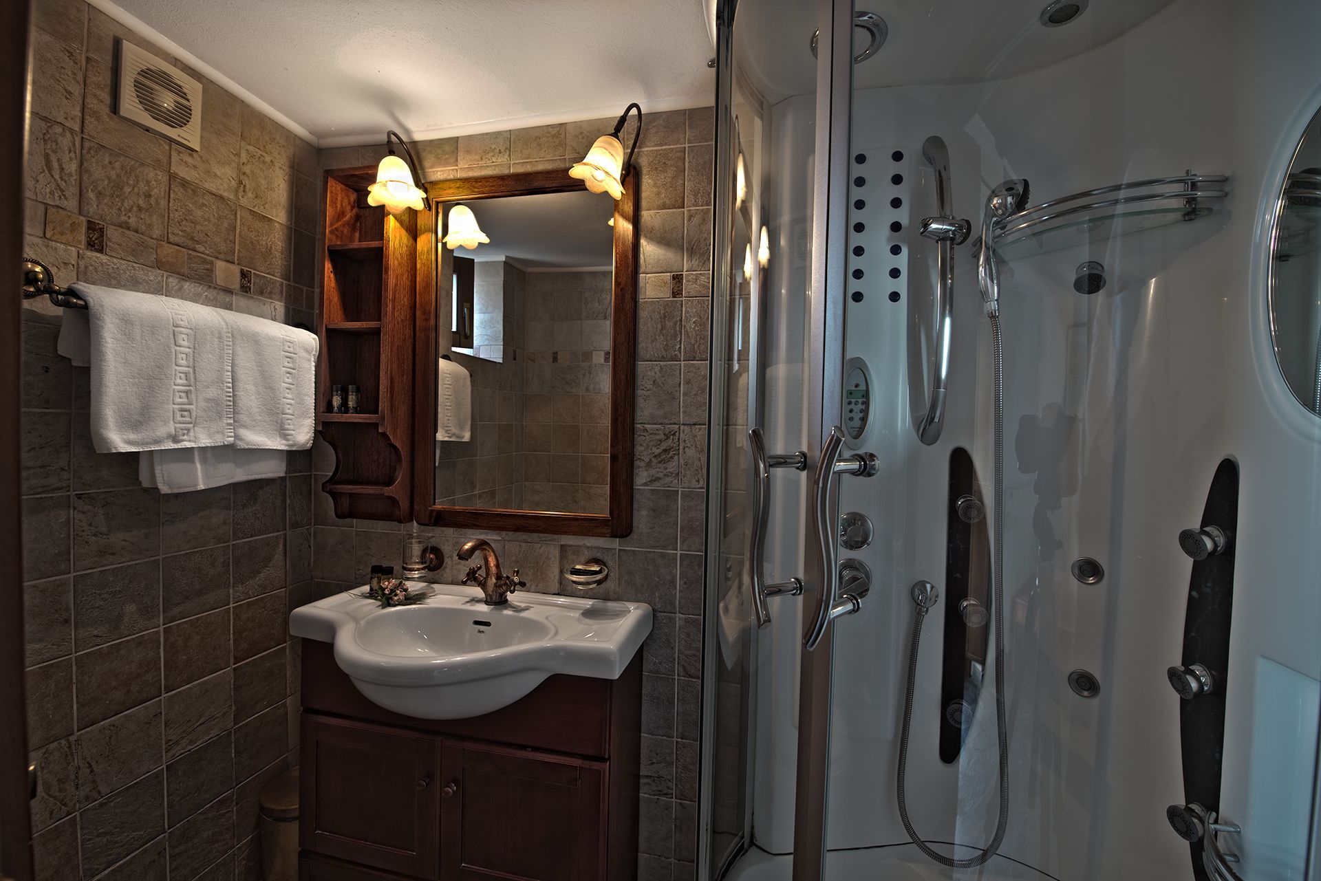 A bathroom with a sink, mirror, and shower.