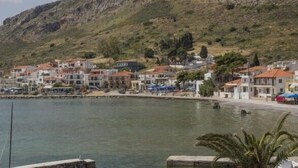 A coastal town with buildings along the waterfront, a clear view of the sea, and a hilly backdrop. - Aktaion Hotel (Monemvasia)