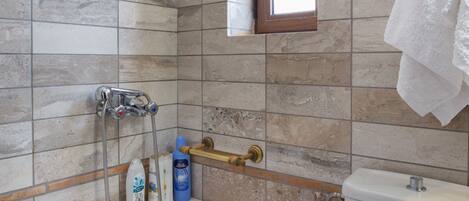 A bathroom with a bathtub, a toilet, and a window.