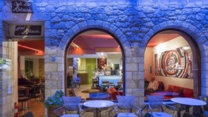 An outdoor cafe area with stone arches, tables, and chairs. - Aktaion Hotel (Monemvasia)