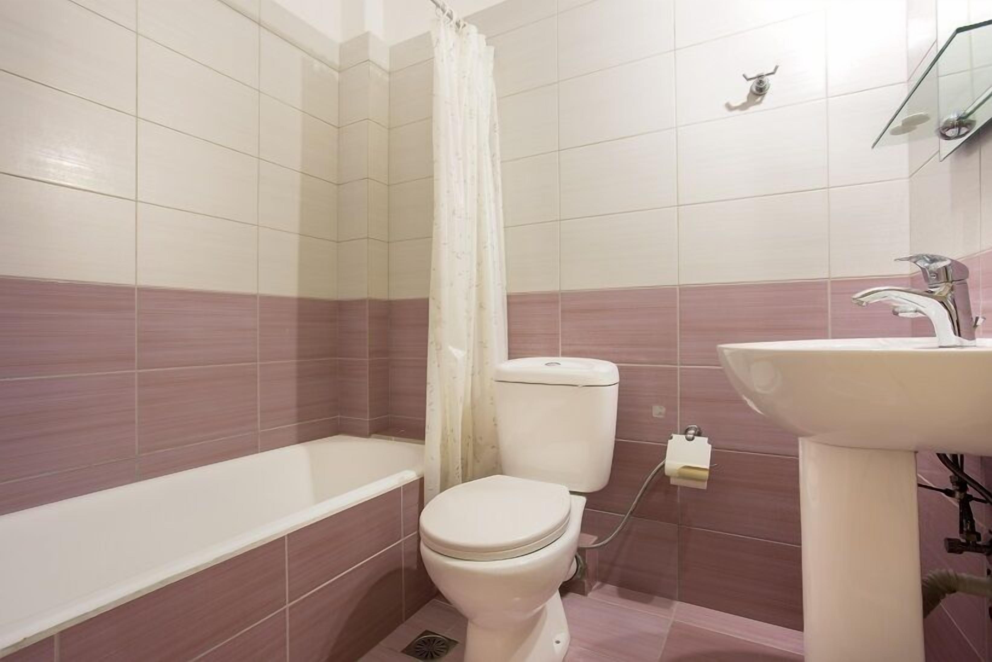 A bathroom with a bathtub, toilet, and sink.
