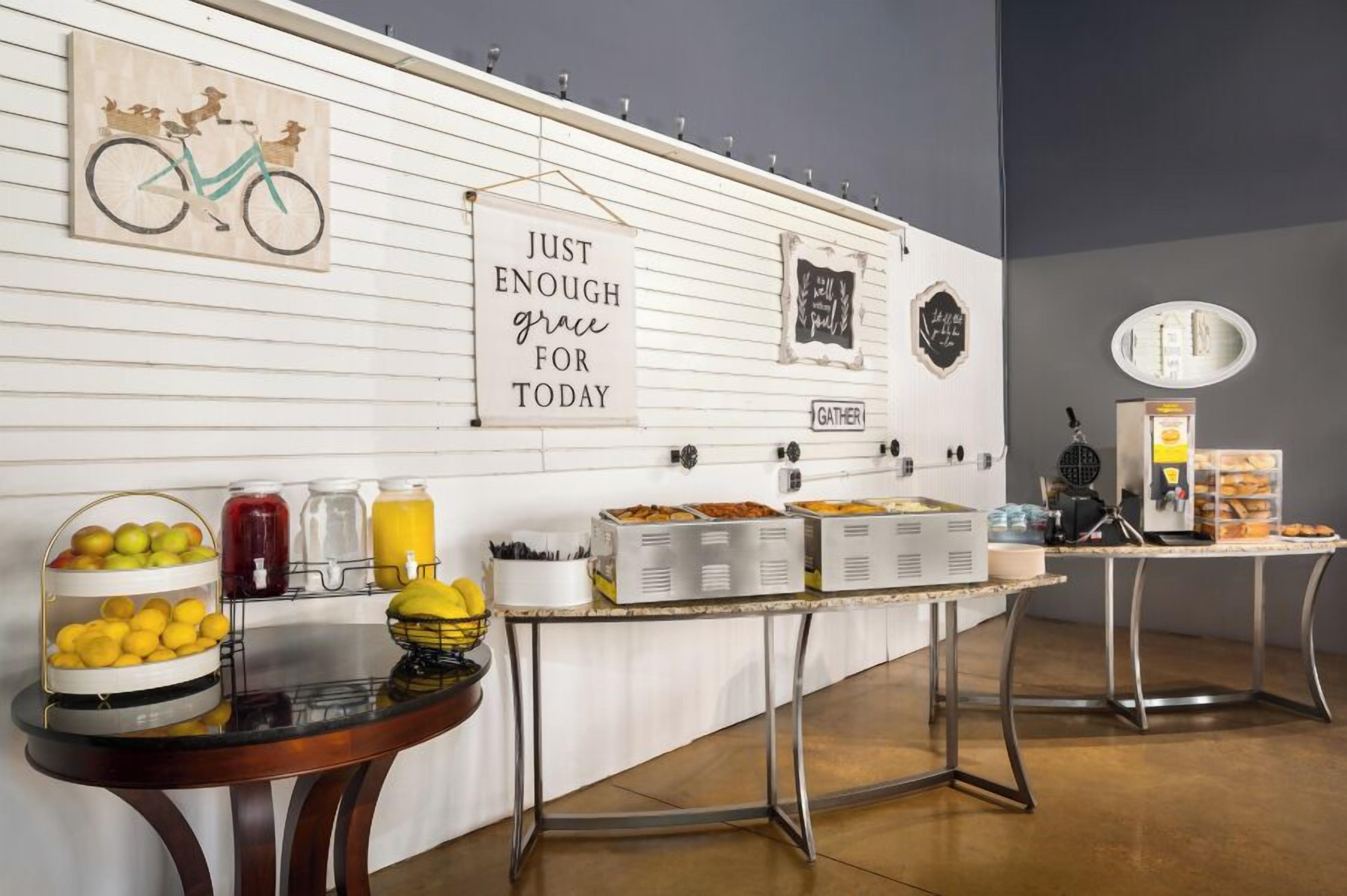 A breakfast buffet setup with various food items and a wall with inspirational quotes.
