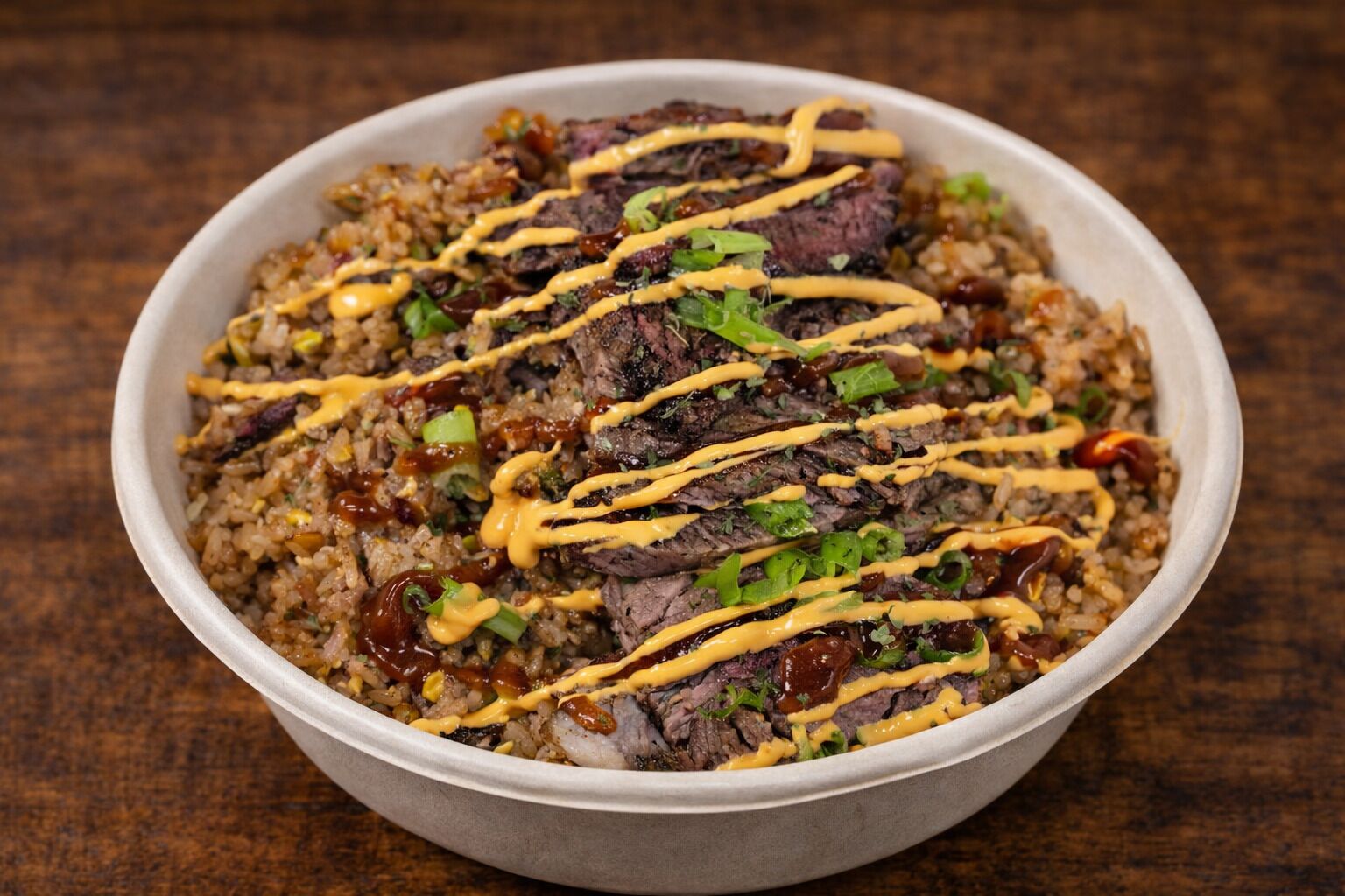 Un plato de comida con arroz, carne y salsas.
