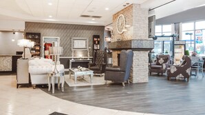 A spacious lobby with a fireplace, seating area, and a reception desk.