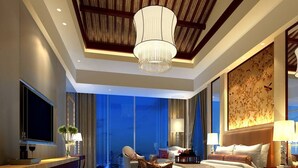 A modern hotel room with a large bed, a desk, a TV, and a view of the cityscape. - Triumphal View Hotel (Dongguan)