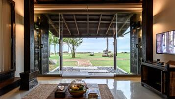 Un interior moderno con un gran ventanal que da a un patio con vistas al océano.