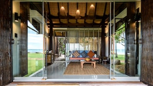 Un intérieur moderne avec une porte vitrée donnant sur un espace détente offrant une vue sur la plage.