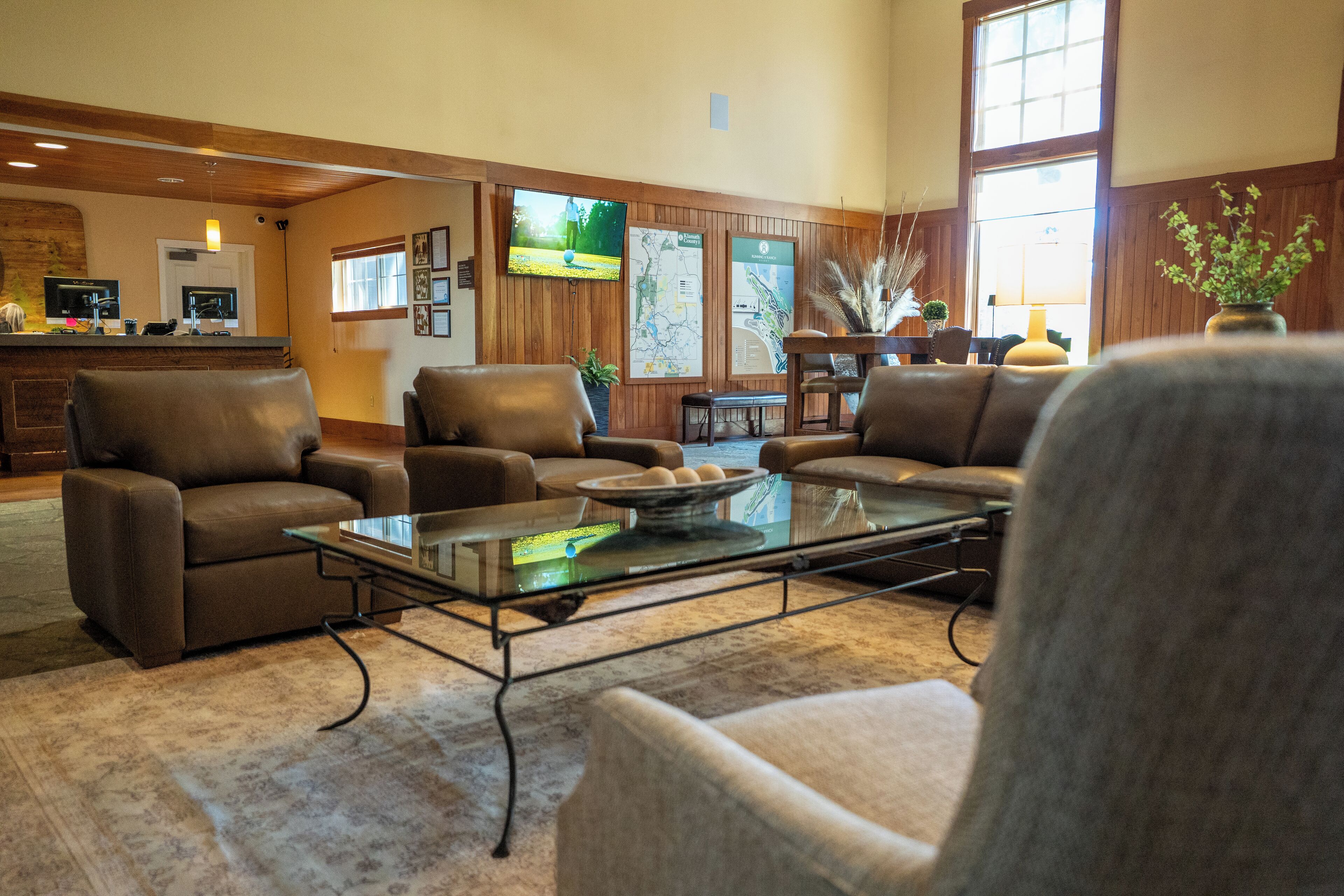 Eine geräumige Lobby mit Ledersofas, einem Glastisch und einer Rezeption.