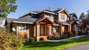 A two-story house with a front porch, a garage, and a well-maintained lawn.