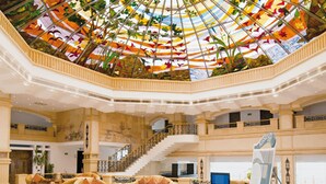 Un hall d’entrée spacieux, doté d’un grand plafond richement décoré et de plusieurs niveaux.