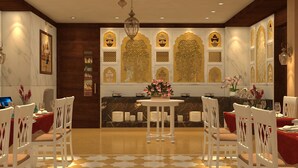 A dining area with white chairs, a round table, and a chandelier.