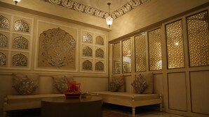 A traditional room with a sofa set, a round coffee table, and decorative wall panels.