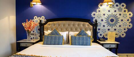 Una cama bien hecha con un edredón estampado, dos almohadas a juego y un adorno de pared decorativo.