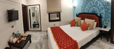 A bedroom with a bed, bedside table, and a mirror.