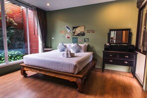 Un dormitorio con una cama grande, un aparador y un espejo.