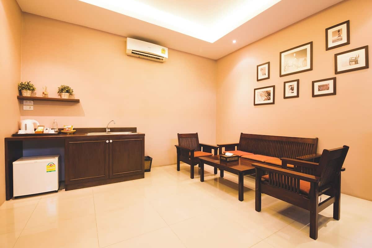 A compact living area with a kitchenette, a sofa, a coffee table, and a dining table.