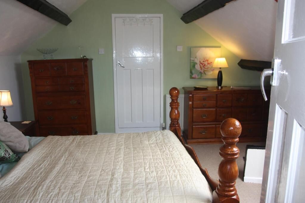 Ein Schlafzimmer mit Bett, Holzschrank und Tür.