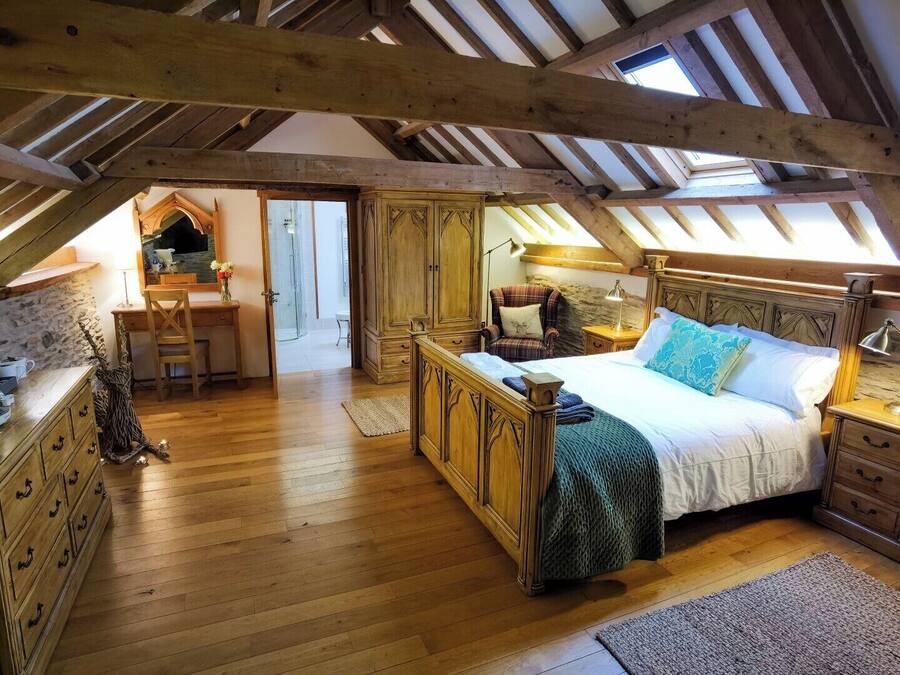 Um quarto de sótão aconchegante com uma cama de madeira, uma escrivaninha e uma cadeira.