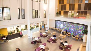 A spacious lobby with multiple seating areas, a reception desk, and a restaurant.