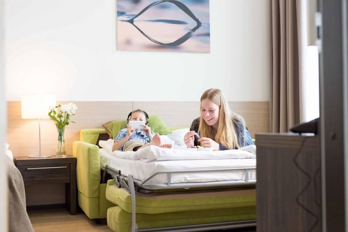 Une chambre d’hôtel avec un lit, une table de chevet, une lampe et un tableau au mur.
