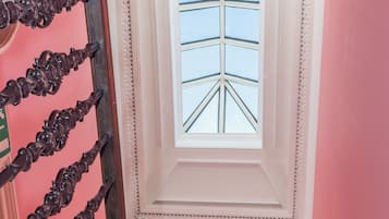 A staircase with ornate black railings leading to a room with a skylight.
