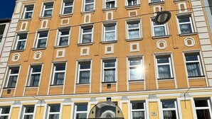 A multi-story building with a yellow facade, multiple windows, and a central entrance with a sign reading "Klimt". - Hotel & Apartments Klimt (Vienna)
