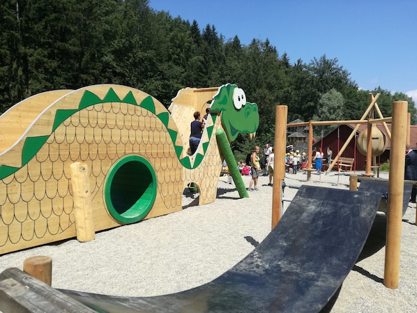 Un espace de jeux pour enfants avec une grande structure en forme de tortue et un toboggan.