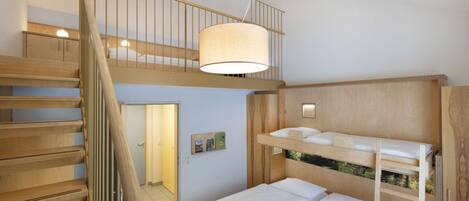 Een kamer met meerdere niveaus, inclusief stapelbedden, een trap en een hangende lamp.