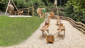 A playground with wooden structures and a rope bridge.