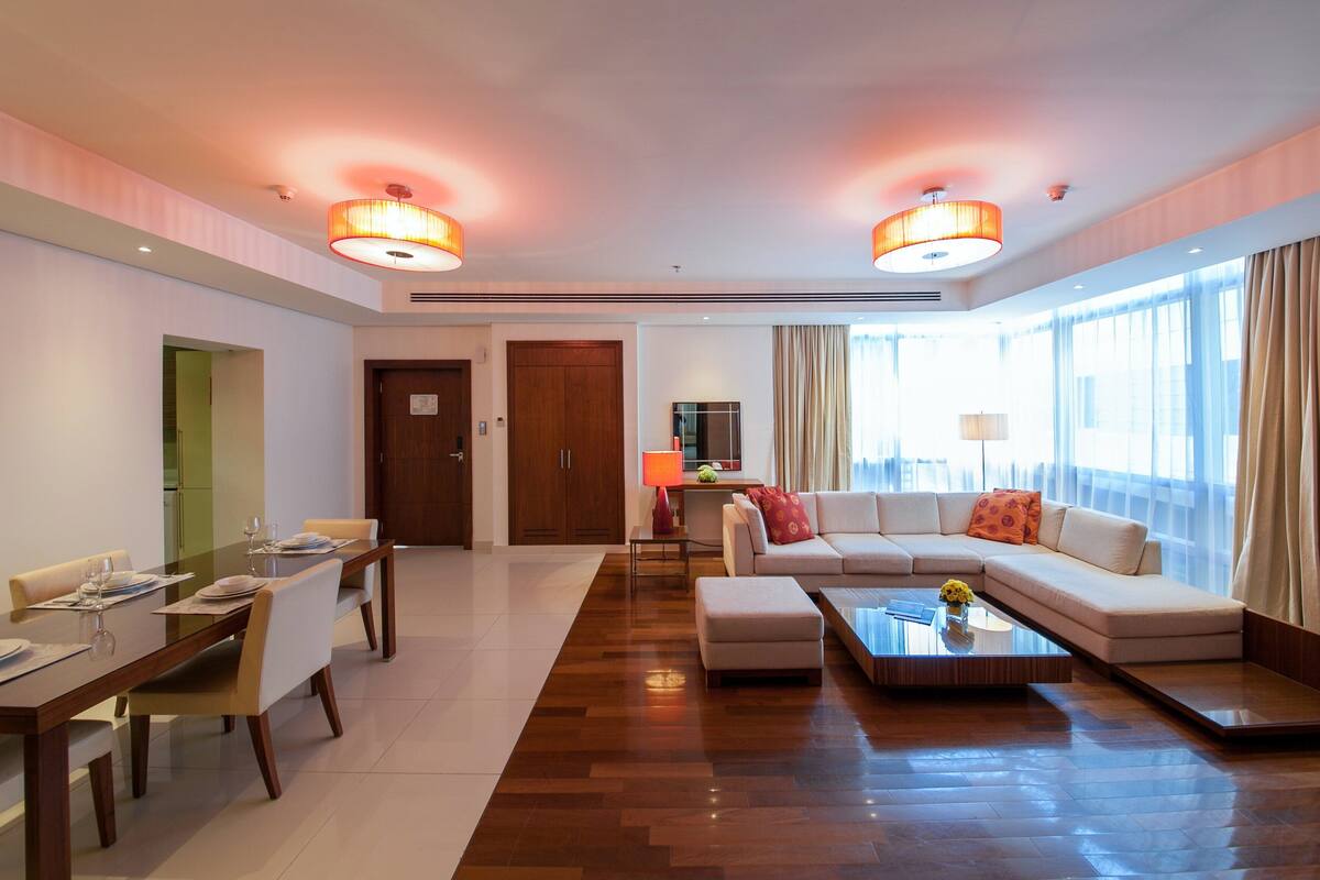 Una habitación de hotel moderna con comedor, sofá y mesa de centro.