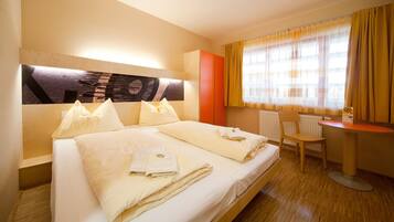 Ropa de cama hipoalergénica y caja de seguridad en la habitación