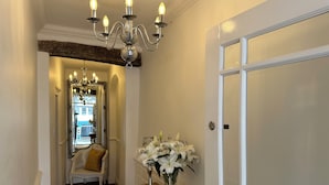 A hallway with a wooden bench, a vase of white lilies, and a white door. - The Barrington Guest House Hotel  (Scarborough)