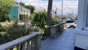 A pathway with a stone balustrade, a palm tree, and a sign for 'Beechwood House' with 'En Suite Rooms' and 'Free Wi-Fi' listed. - Beechwood House (St Ives)