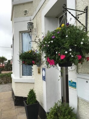 A building with hanging flower baskets and a sign that reads 'stives'. - Beechwood House (St Ives)