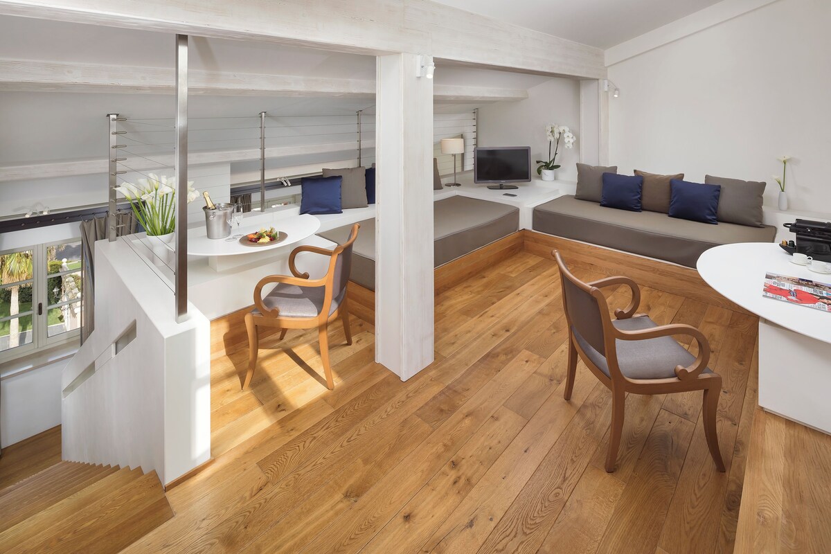 Una cocina moderna con comedor, suelo de madera y vistas al exterior.