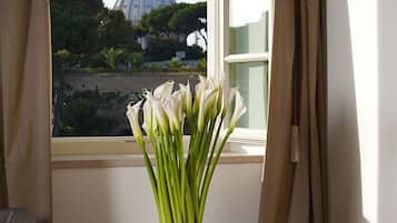 Una habitación con vistas a una cúpula, un jarrón con flores blancas, una botella de champán y una copa sobre una mesa.