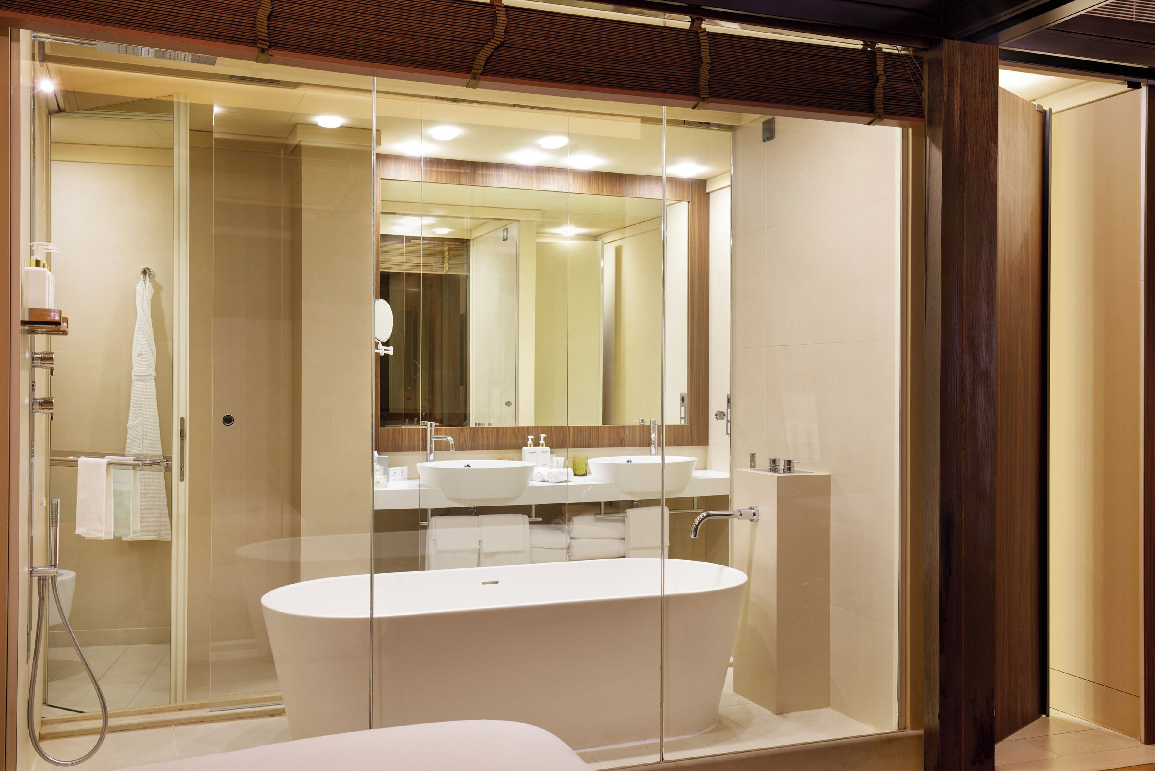 Un bagno moderno con doccia vetrata, una vasca da bagno indipendente e un grande specchio sopra il lavabo.