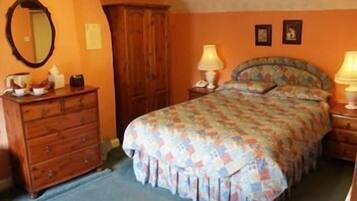 A bedroom with a bed, dresser, and two bedside lamps.