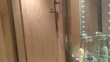 A wooden door with a towel rack and a glass cabinet with bottles.