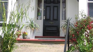 A building with a black door, white walls, and a red threshold. - Bryn Derwen Guest House (Conwy)