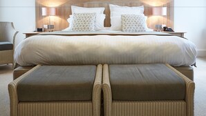 A neatly made bed with a wooden headboard, two bedside lamps, and a telephone on the nightstand.