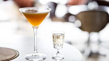 A martini glass and a small glass on a round table.