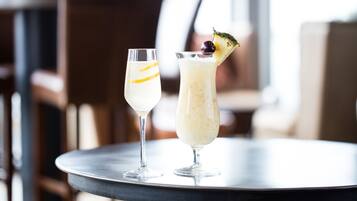 Two drinks on a round table in a restaurant setting.