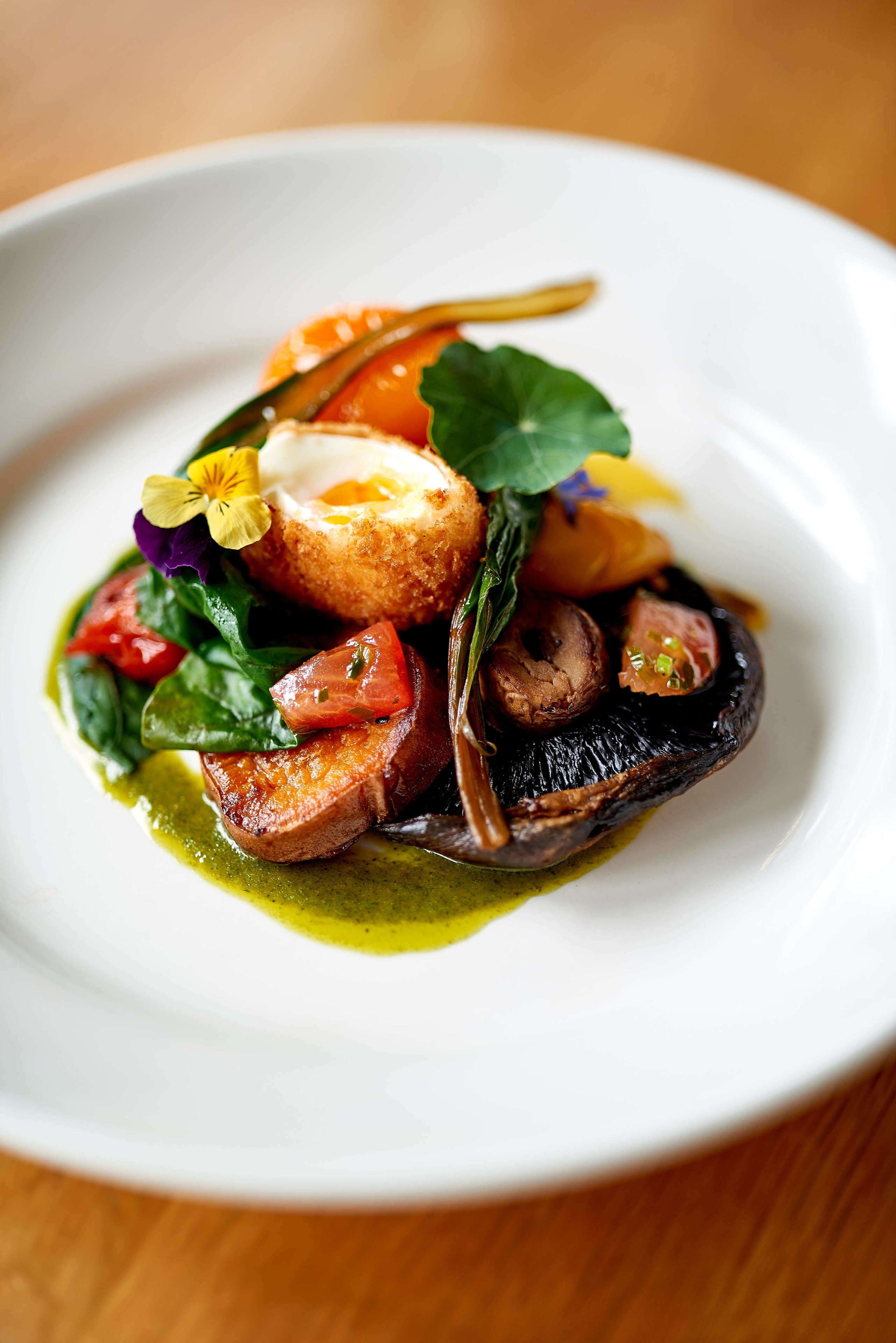 A plate of food with a variety of vegetables and a poached egg.
