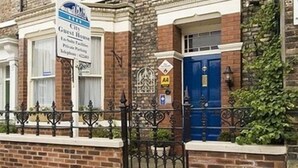 A brick building with a sign indicating it's a City Guest House. - City Guest House (York)
